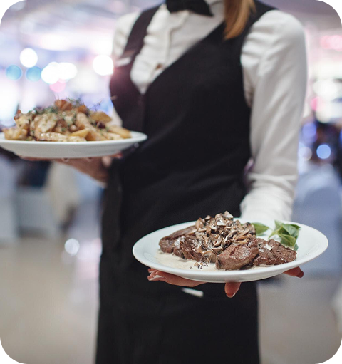 Mesera con 2 platos de comida, una con pollo y la otra con res