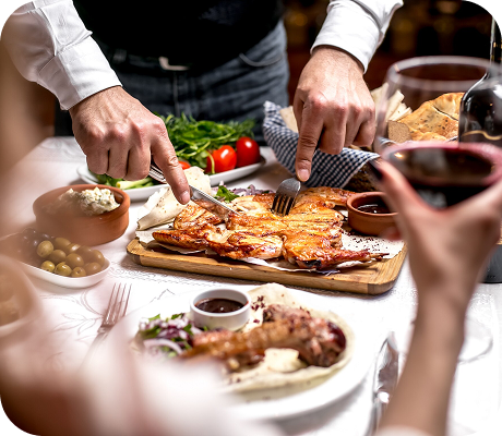 Pollo asado en plancha en una mesa con verduras y vino